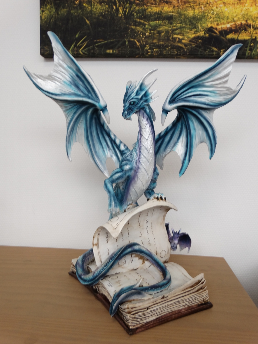 Blue dragon on book, with small purple dragon