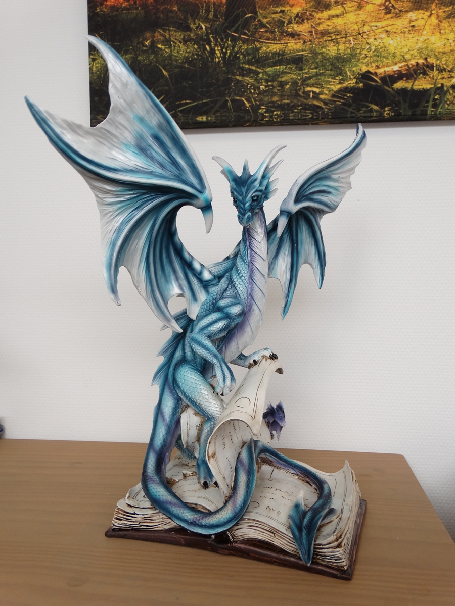 Blue dragon on book, with small purple dragon